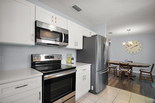 kitchen featuring light tile patterned flooring, visible vents, a chandelier, light countertops, and appliances with stainless steel finishes