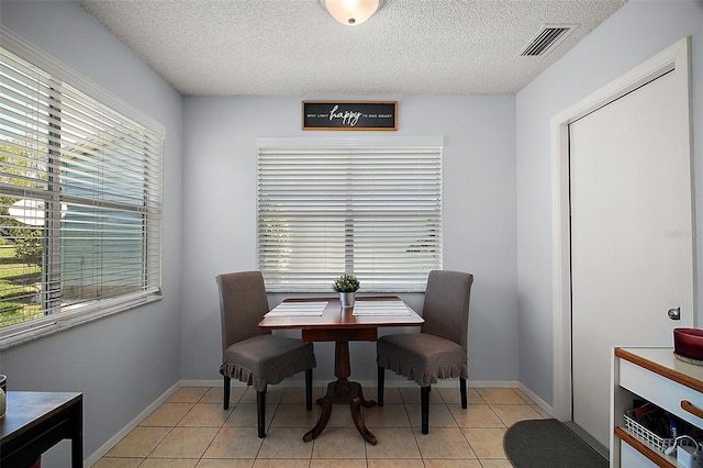 dining area with a textured ceiling, visible vents, and a wealth of natural light