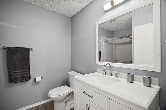 bathroom with wood finished floors, visible vents, toilet, a textured ceiling, and a stall shower