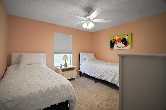 bedroom featuring a textured ceiling, light colored carpet, and ceiling fan
