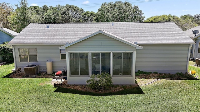 rear view of property with a lawn, a sunroom, and central air condition unit