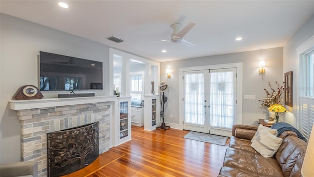 908 N Tremain St, Mount Dora, FL 32757 - living area featuring ceiling fan, a brick fireplace, french doors, wood finished floors, and visible vents