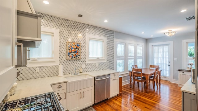 908 N Tremain St, Mount Dora, FL 32757 - kitchen featuring visible vents, appliances with stainless steel finishes, wood finished floors, a sink, and light countertops