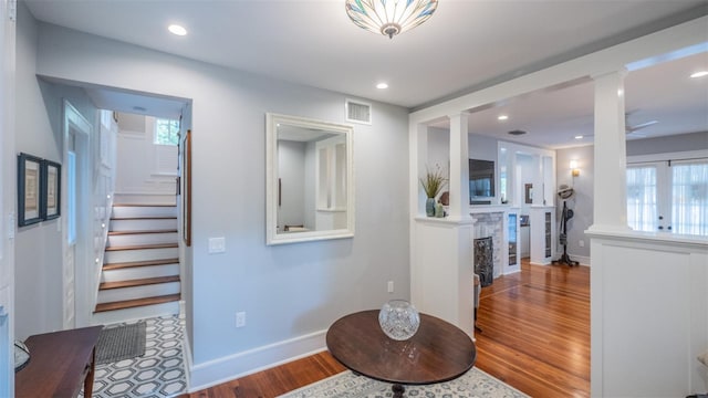 908 N Tremain St, Mount Dora, FL 32757 - entrance foyer with visible vents, a fireplace, stairs, wood finished floors, and ornate columns