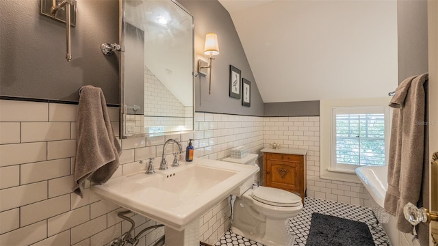 908 N Tremain St, Mount Dora, FL 32757 - full bathroom with toilet, tile walls, a bathtub, tile patterned floors, and vaulted ceiling