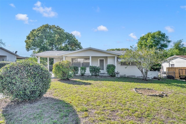 ranch-style house featuring fence and a front lawn