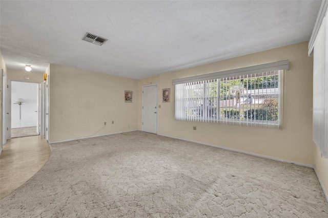 unfurnished living room featuring baseboards, visible vents, and carpet flooring