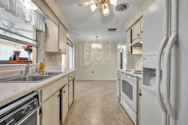 kitchen with a sink, white appliances, light countertops, under cabinet range hood, and visible vents