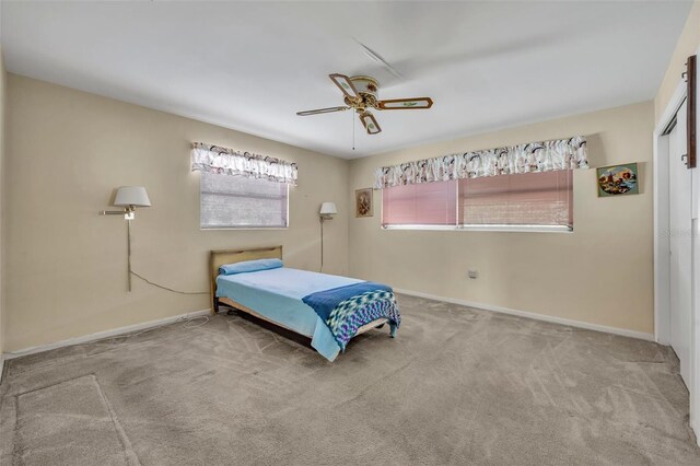 carpeted bedroom featuring ceiling fan and baseboards