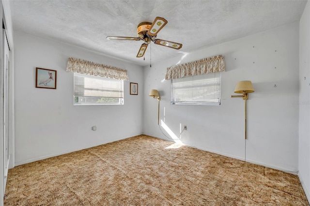 empty room with carpet floors and a ceiling fan