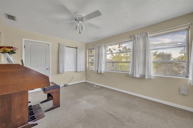 unfurnished office with baseboards, visible vents, carpet, and ceiling fan
