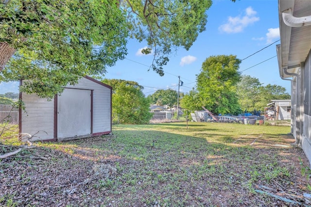 view of yard with fence, an outbuilding, and a storage unit