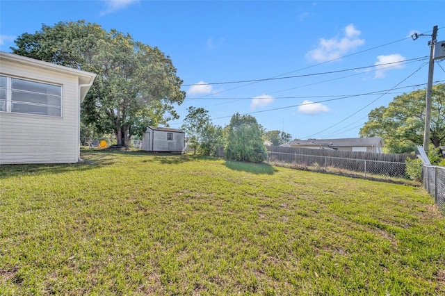 view of yard featuring an outdoor structure, a storage unit, and a fenced backyard