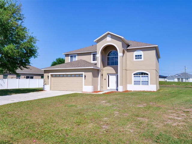 view of front of property with fence, stucco siding, an attached garage, driveway, and a front yard