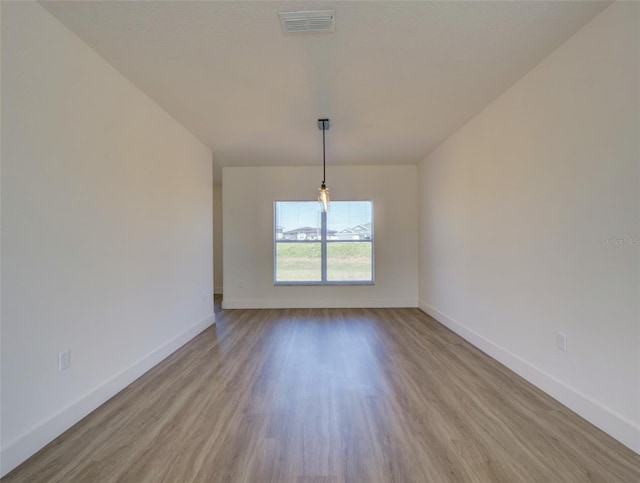 unfurnished dining area featuring wood finished floors, visible vents, and baseboards
