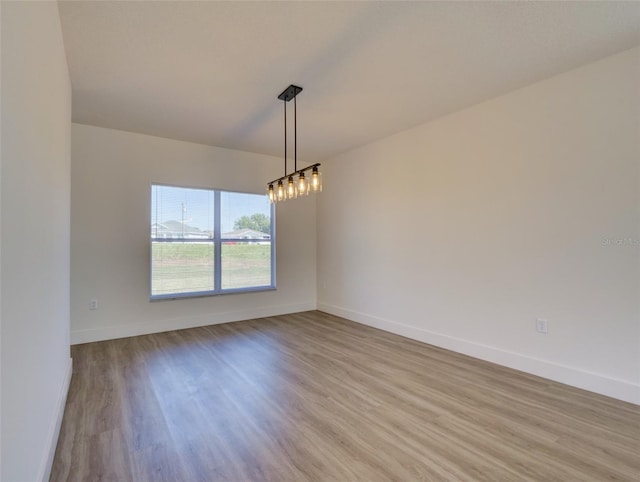 empty room featuring baseboards and wood finished floors