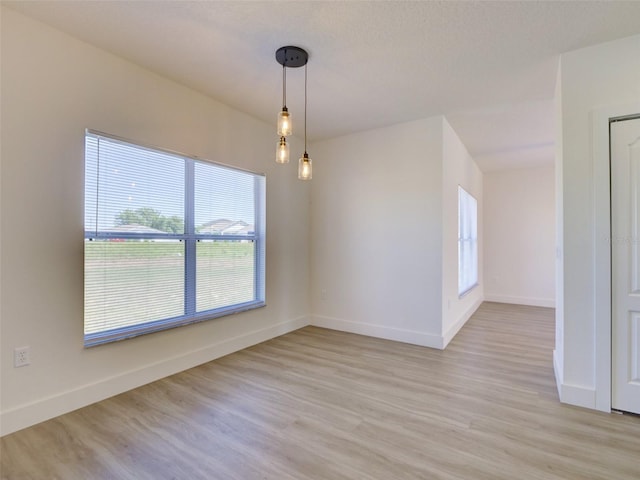 empty room featuring baseboards and light wood-style floors