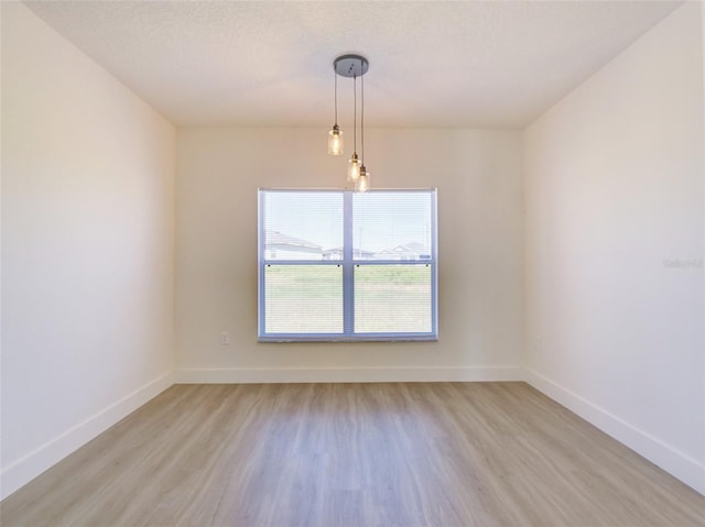 unfurnished room featuring baseboards and light wood-style floors