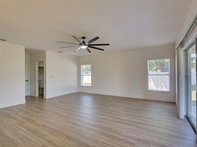 unfurnished room with light wood finished floors, baseboards, ceiling fan, and a healthy amount of sunlight