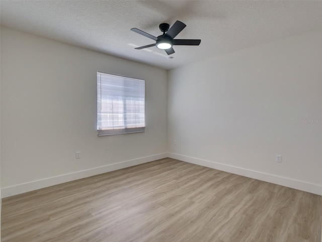 unfurnished room featuring ceiling fan, baseboards, a textured ceiling, and light wood-type flooring