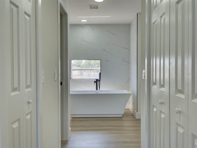 hall featuring visible vents and wood finished floors