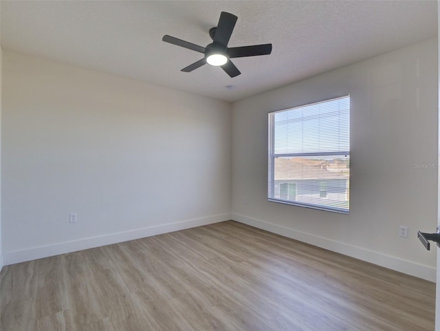 unfurnished room featuring light wood finished floors, baseboards, and a ceiling fan