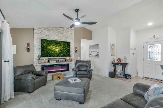 living area with a stone fireplace, ceiling fan, carpet, lofted ceiling, and visible vents