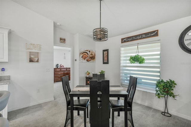dining space featuring light colored carpet and baseboards