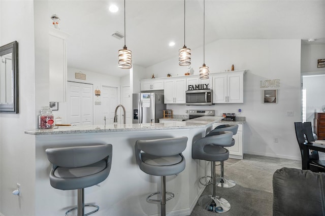 kitchen with a breakfast bar, stainless steel appliances, lofted ceiling, white cabinetry, and visible vents