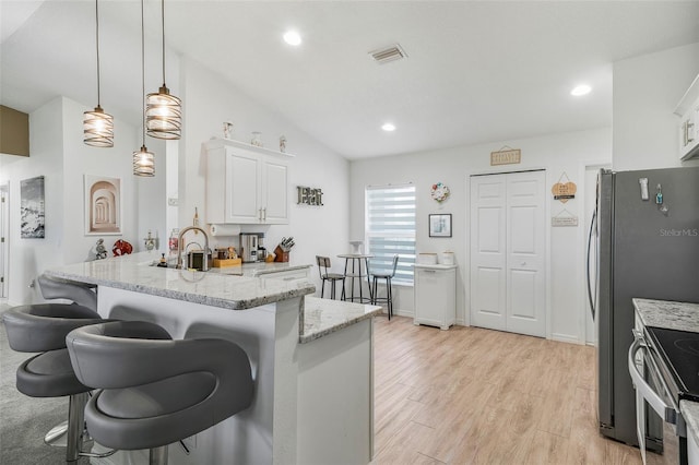 kitchen featuring white cabinets, lofted ceiling, visible vents, a peninsula, and a breakfast bar area