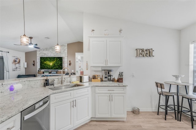 kitchen with lofted ceiling, light stone counters, dishwasher, a sink, and light wood-style flooring