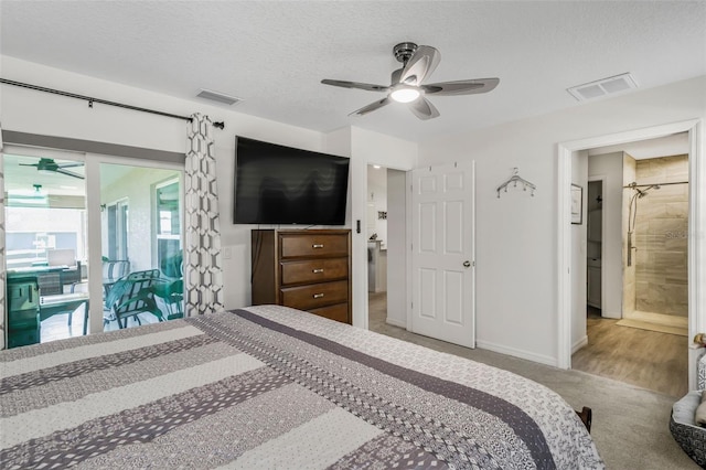 bedroom featuring a textured ceiling, visible vents, carpet flooring, and baseboards