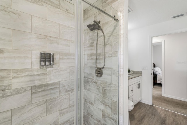 bathroom featuring wood finished floors, visible vents, vanity, and a stall shower