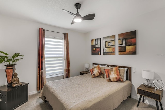 bedroom featuring light carpet, a ceiling fan, and baseboards