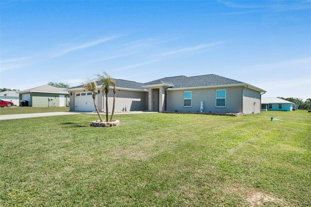 view of front of property with concrete driveway, a front yard, and a garage