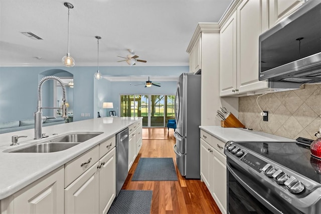 14820 Potterton Cir, Hudson, FL 34667 - kitchen with stainless steel appliances, a ceiling fan, light countertops, wood finished floors, and backsplash