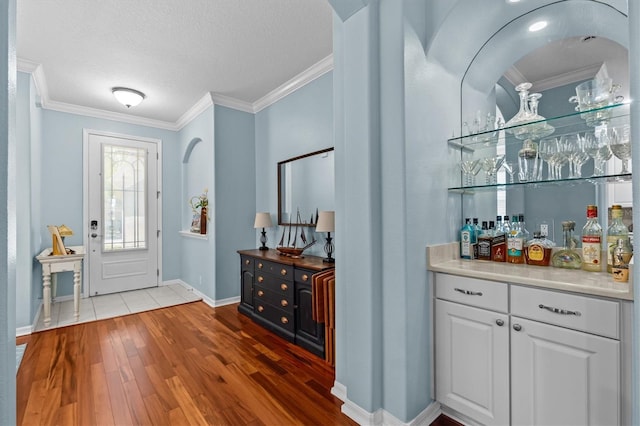14820 Potterton Cir, Hudson, FL 34667 - entryway with wood finished floors, a bar, ornamental molding, and a textured ceiling