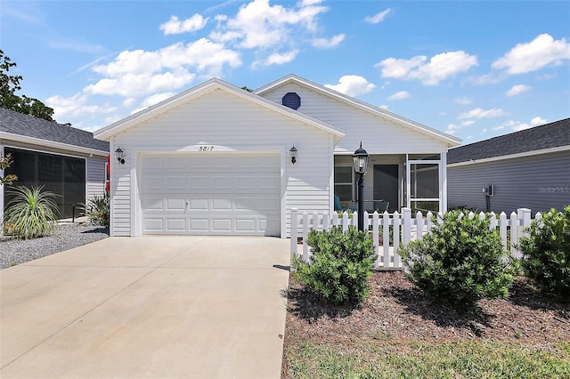 ranch-style home with a garage, fence, a sunroom, and concrete driveway