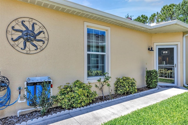 doorway to property featuring stucco siding