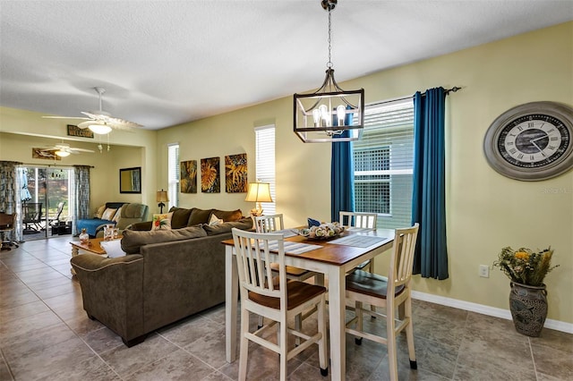 tiled dining room featuring a chandelier, ceiling fan, and a textured ceiling