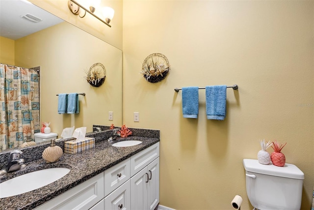 bathroom featuring toilet, double vanity, and curtained shower