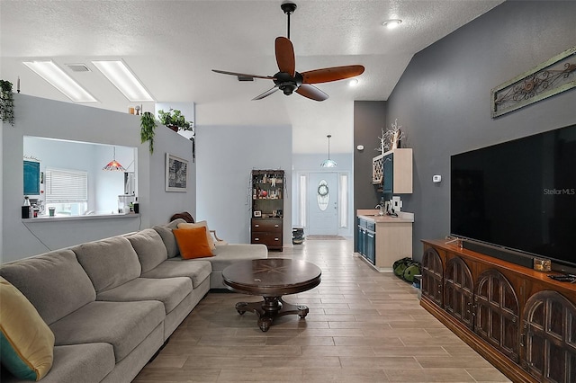 38 Townhill Dr, Eustis, FL 32726 - living area with high vaulted ceiling, light wood-type flooring, a ceiling fan, visible vents, and a textured ceiling