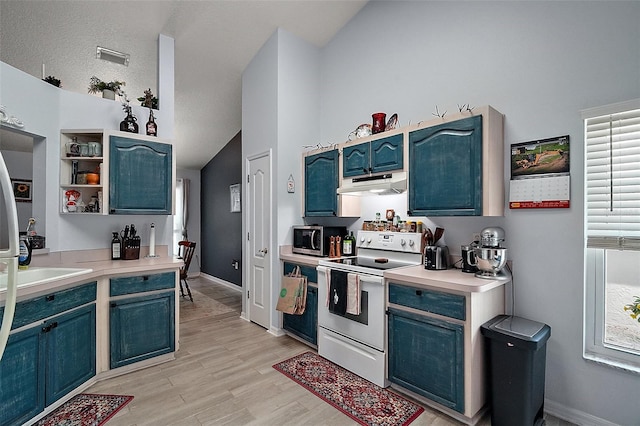 38 Townhill Dr, Eustis, FL 32726 - kitchen with stainless steel microwave, under cabinet range hood, white electric range oven, blue cabinetry, and vaulted ceiling
