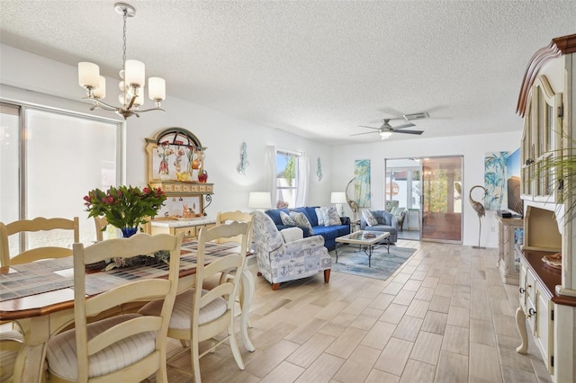 732 Ramirez Ave, The Villages, FL 32159 - dining space with light wood-style floors, ceiling fan with notable chandelier, a textured ceiling, and visible vents