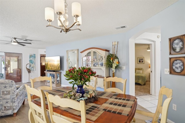 732 Ramirez Ave, The Villages, FL 32159 - dining area featuring arched walkways, a textured ceiling, ceiling fan with notable chandelier, light tile patterned floors, and visible vents