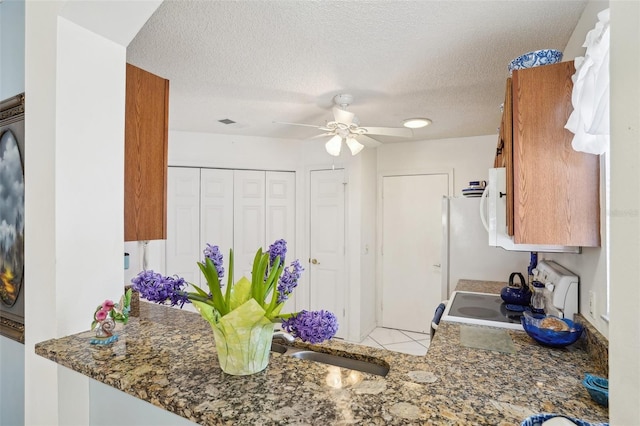 732 Ramirez Ave, The Villages, FL 32159 - kitchen featuring electric range, stone countertops, a textured ceiling, and ceiling fan