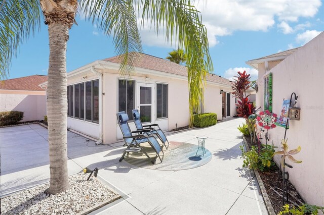 732 Ramirez Ave, The Villages, FL 32159 - rear view of property featuring a sunroom, a patio area, and stucco siding