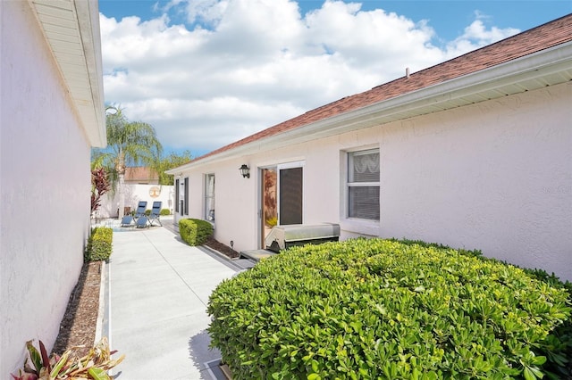 732 Ramirez Ave, The Villages, FL 32159 - view of property exterior featuring fence, a patio, stucco siding, and roof with shingles