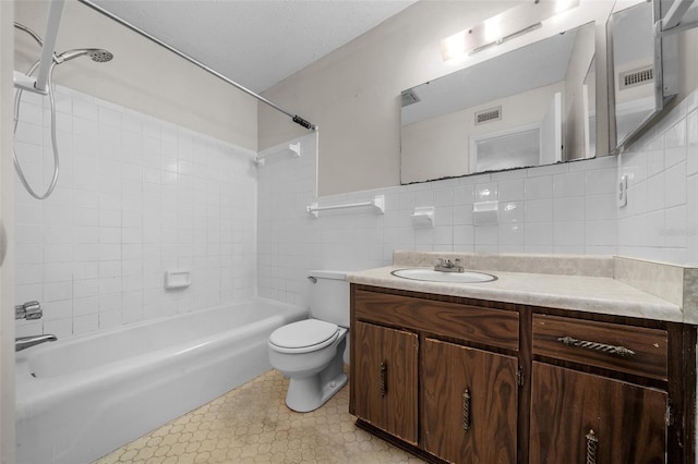 full bath featuring tile walls, washtub / shower combination, vanity, toilet, and visible vents