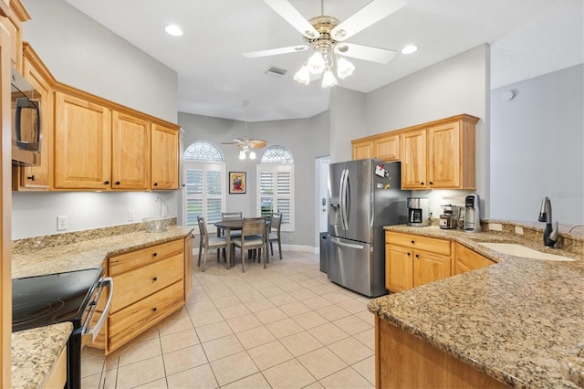 2120 Callaway Dr, The Villages, FL 32162 - kitchen with light stone countertops, light tile patterned floors, appliances with stainless steel finishes, a sink, and a ceiling fan
